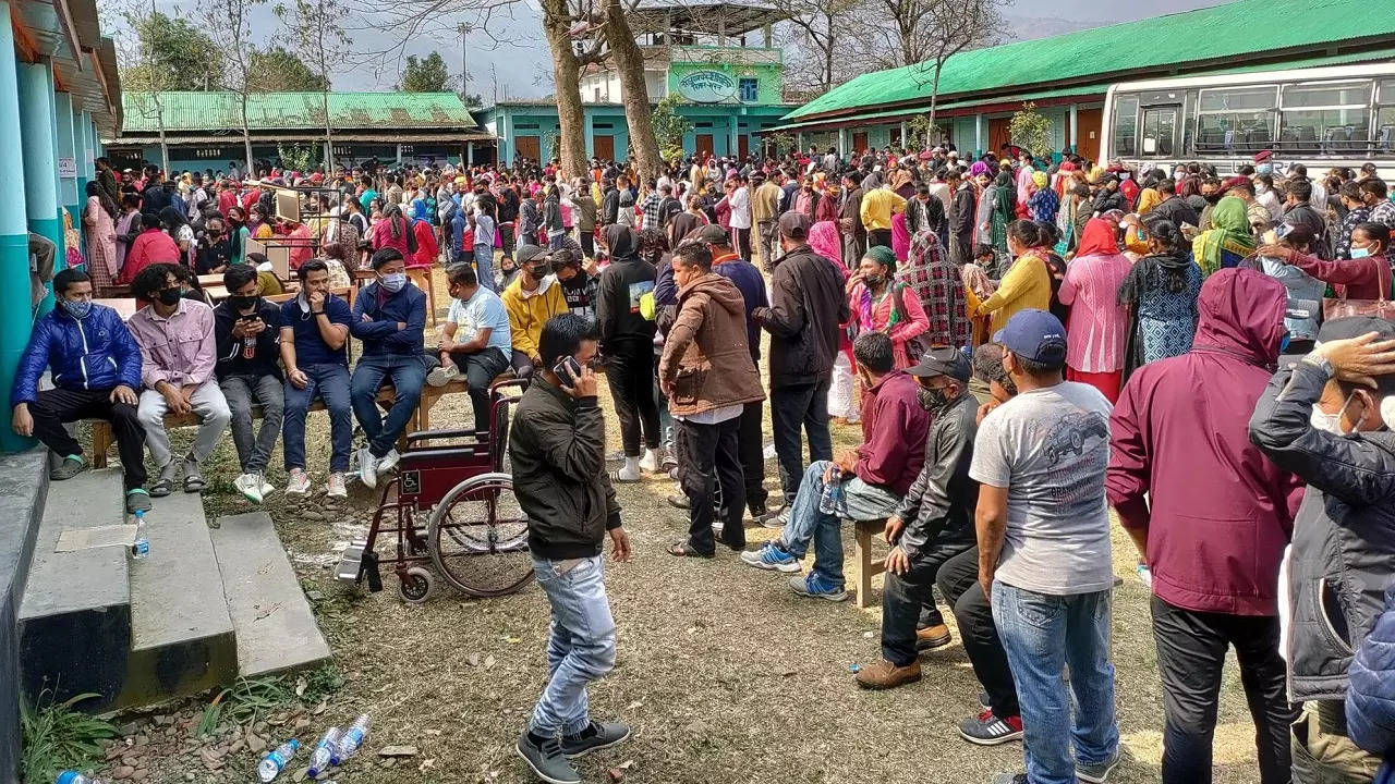 Voters wait outside a polling booth during the first phase of Manipur state elections in Imphal