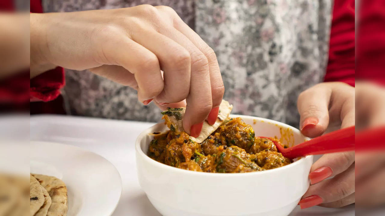 woman eating chapatti (roti) with Potato curry (Kashmiri dum aloo