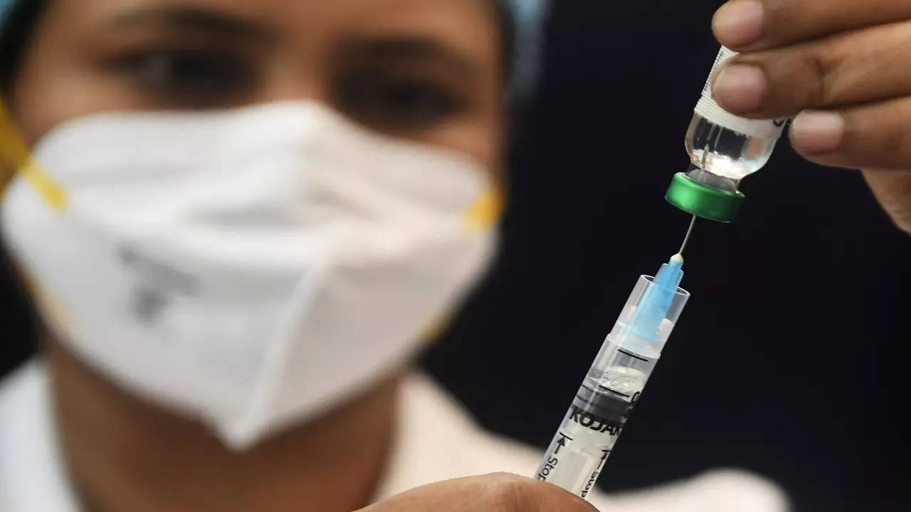 A healthcare worker prepares to vaccinate beneficiaries