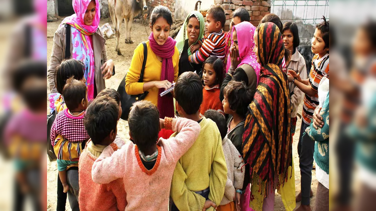 teacher talks to students in village