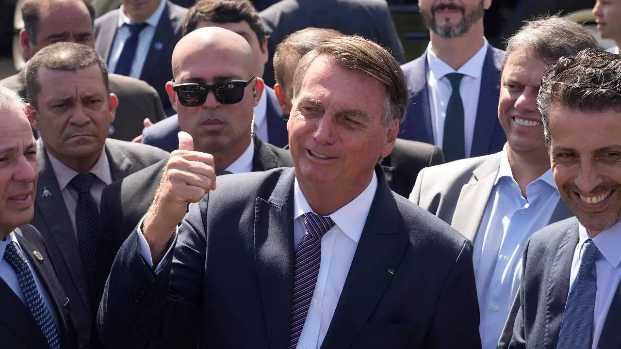 Brazilian President Jair Bolsonaro gives a thumbs up to supporters gathered outside the presidential residence Alvorada Palace on his 67th birthday in Brasilia