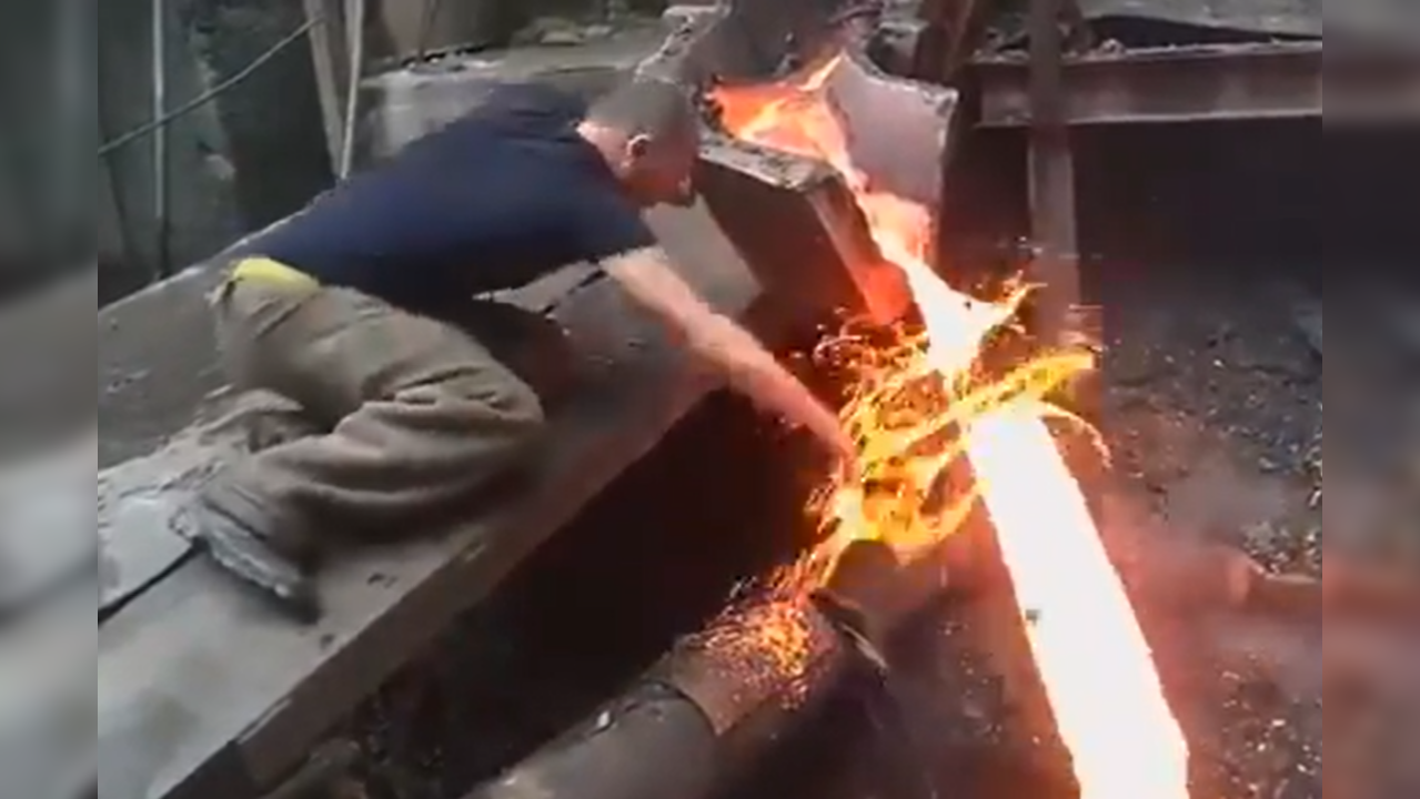 Man passes bare hand through molten metal