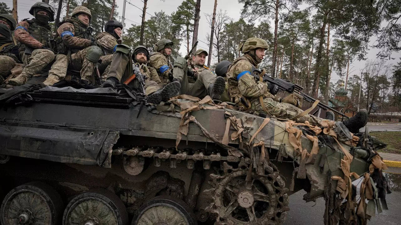 Ukrainian servicemen ride on a fighting vehicle outside Kyiv, Ukraine, Saturday, April 2, 2022.