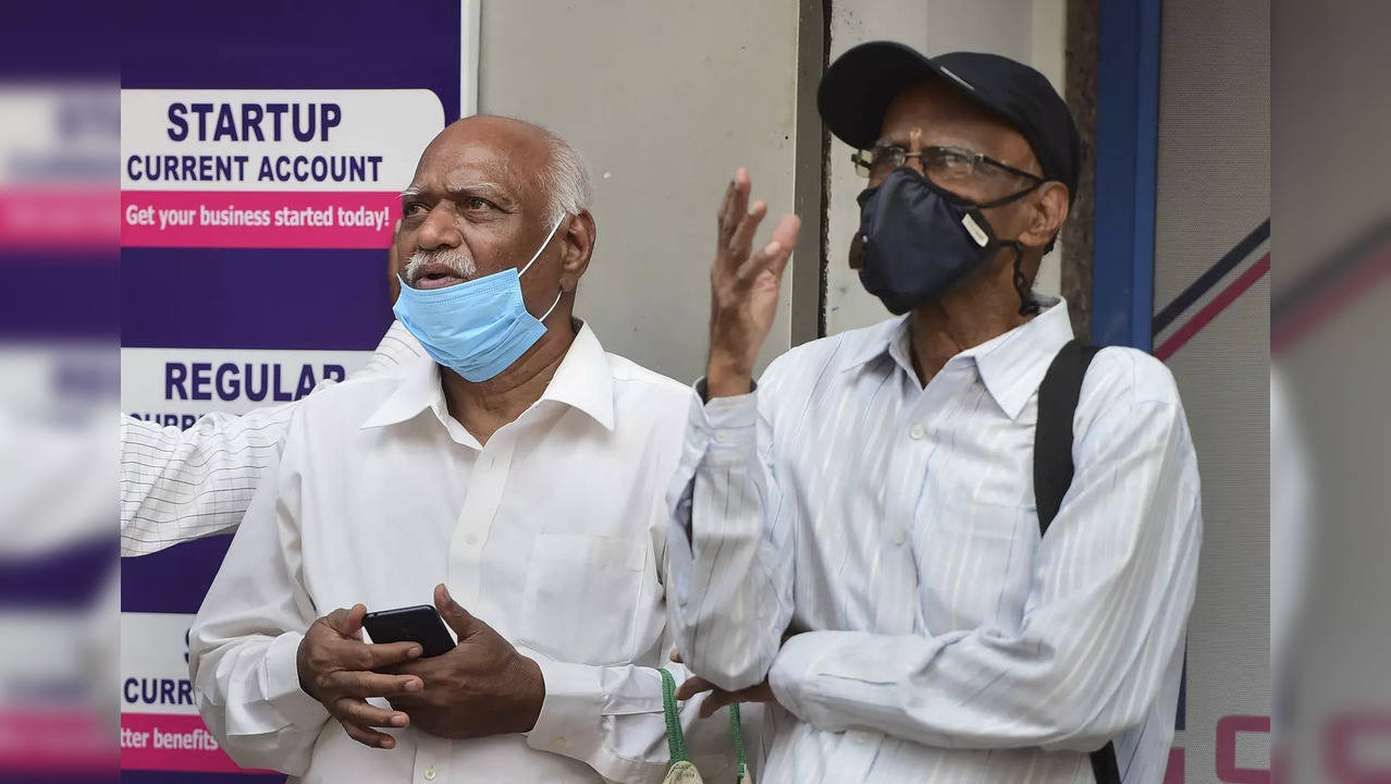 People examine the Sensex updates on a screen outside the Bombay Stock E...