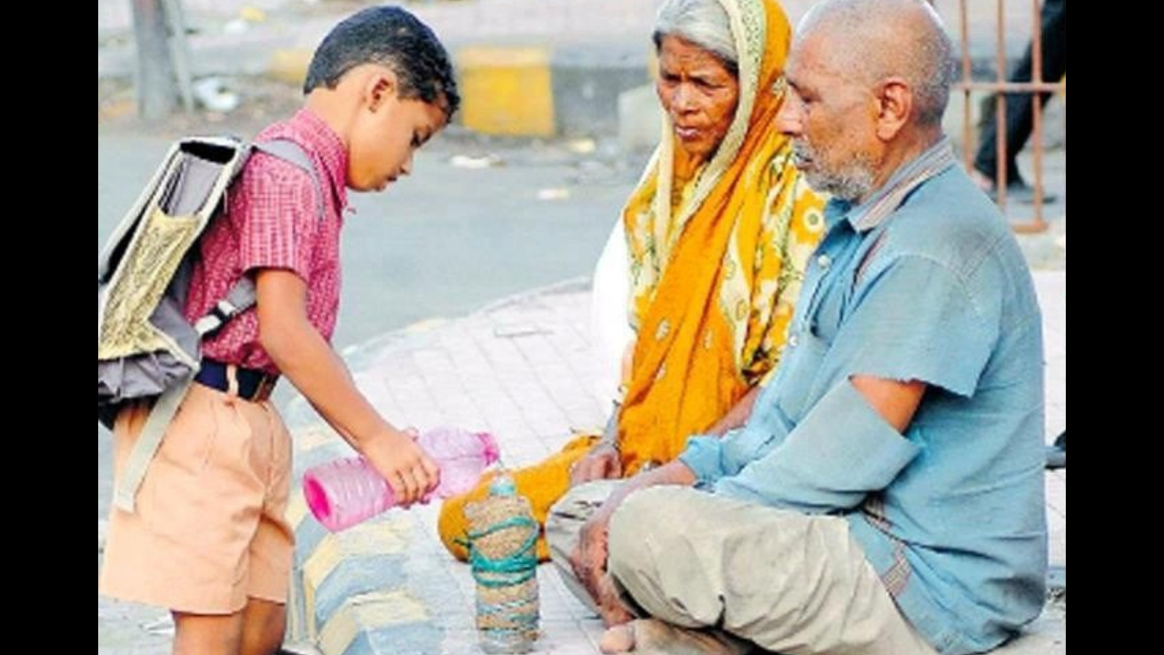 Little boy offers water from his bottle to elderly couple on street