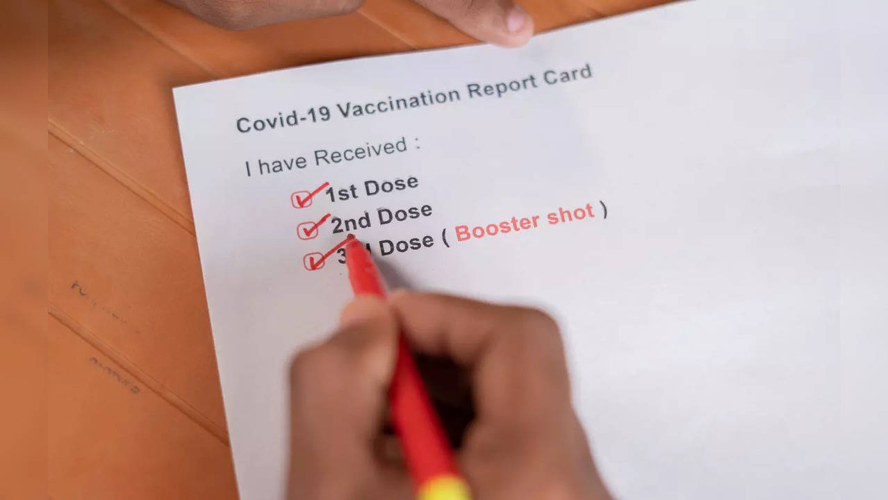 Hands checking Covid-19 vaccine report card