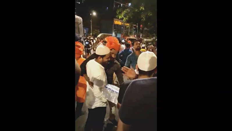 A procession in Jogeshwari greeted by Muslim men handing out water bottles