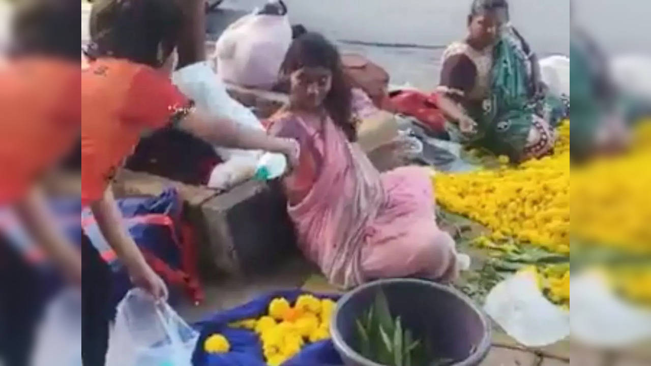 Little boy hands out Bisleris to flower sellers