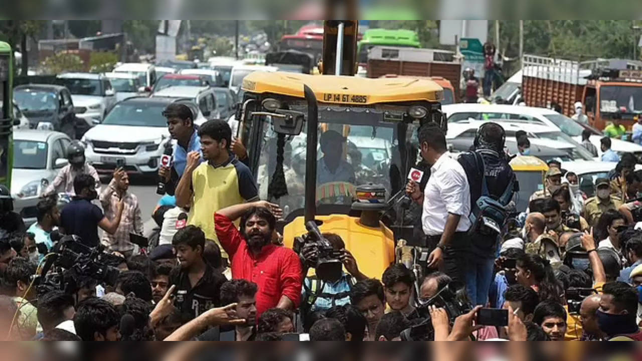 Locals stage a protest in front of a Municipal Corporation of Delhi (MCD) bulldozer at Shaheen Bagh area during an anti-encroachment drive