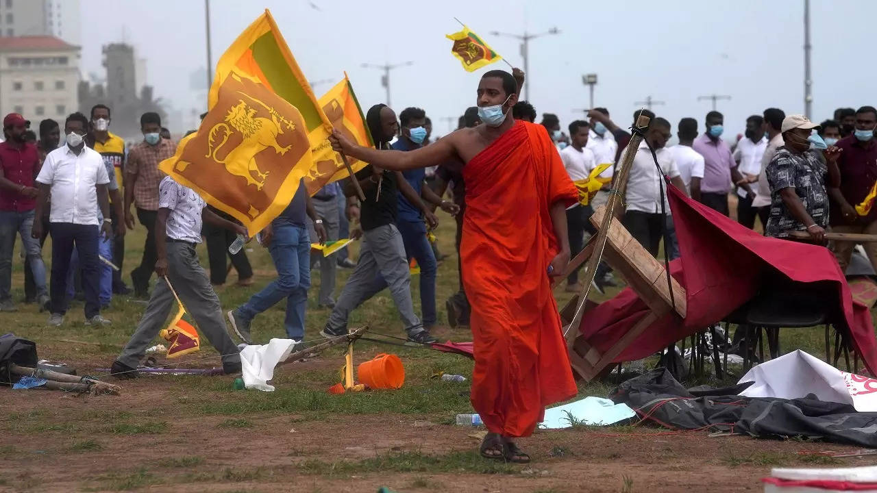 A Buddhist monk joins other government supporters in vandalizing the site of anti-government protests outside the president's office in Colombo