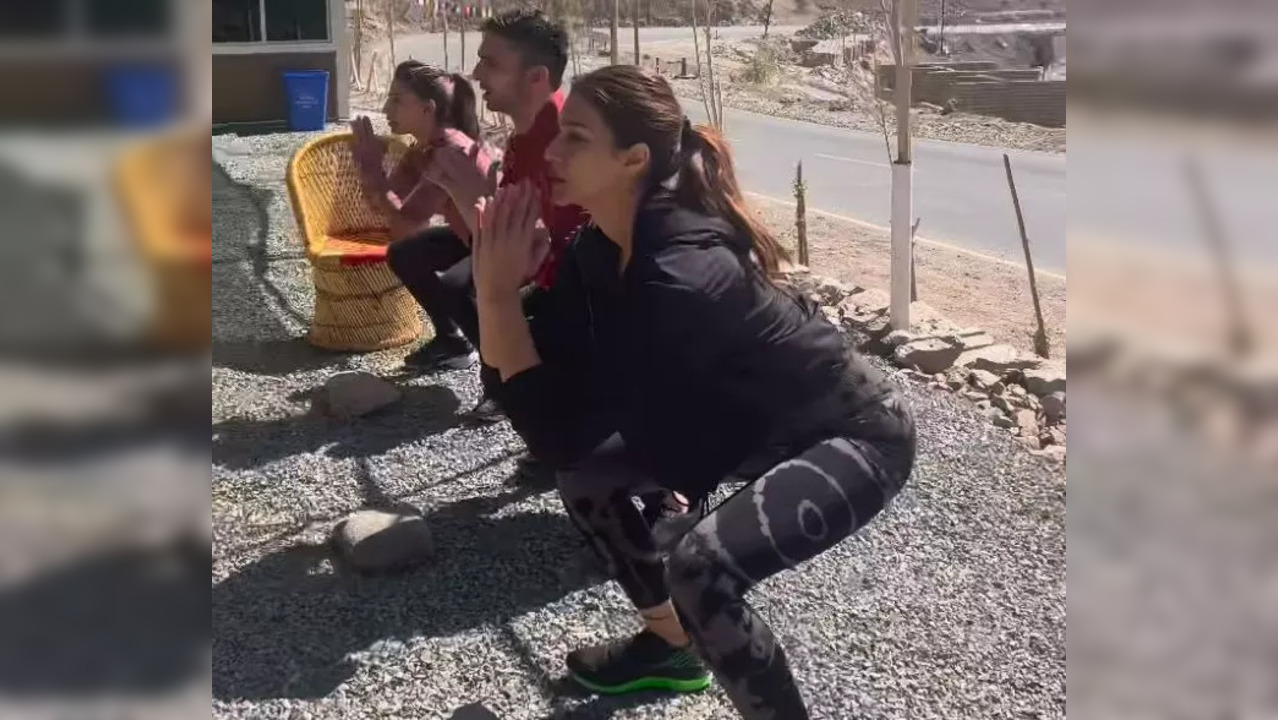 Accompanied by her team, Kriti Sanon is seen using rocks as weights to perform squats. (Photo credit: Kriti Sanon/Instagram)