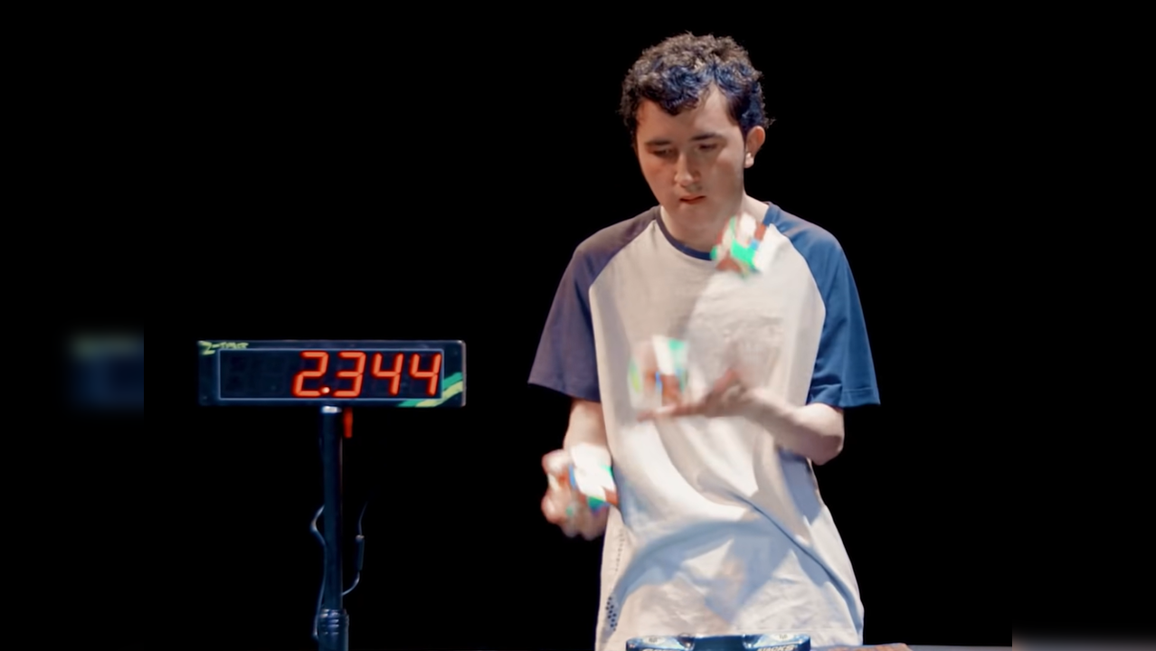 Teen solves three Rubik's cubes while juggling them