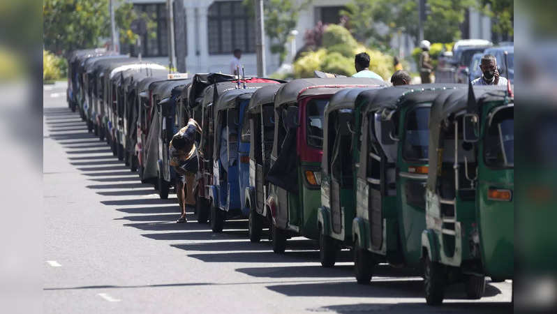 Autorickshaws are parked in a queue for gasoline near a fuel station in Colombo,...
