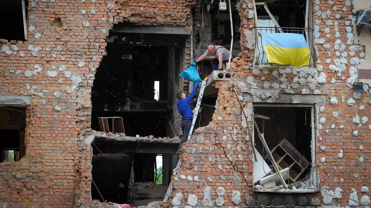 Residents take out their belongings from their house ruined by the Russian shelling in Irpin