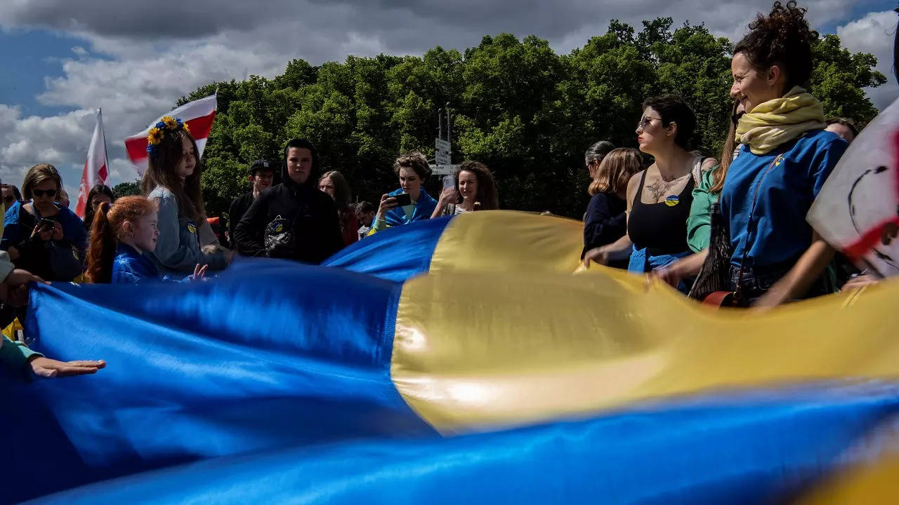 Participants hold a giant Ukrainian flag during a demonstration against the war in Ukraine at the Brandenburg Gate