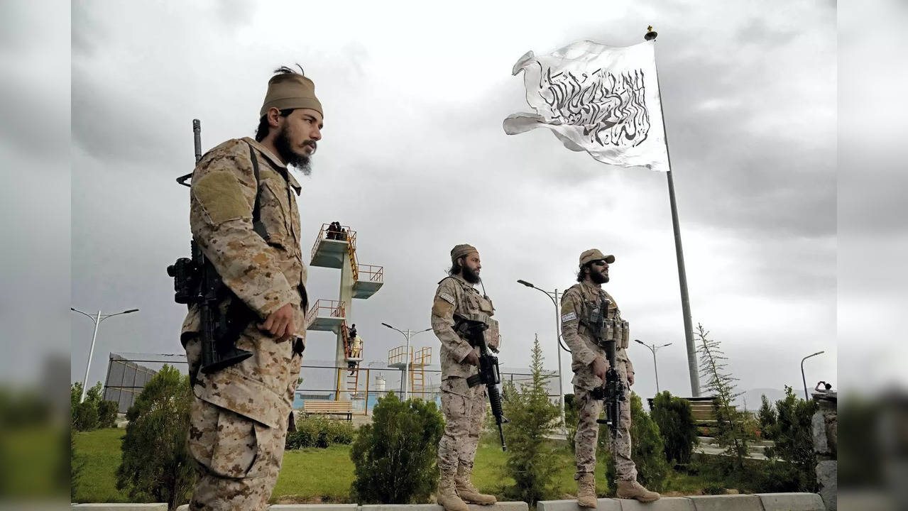 Taliban special forces stand guard in front of the Taliban flag