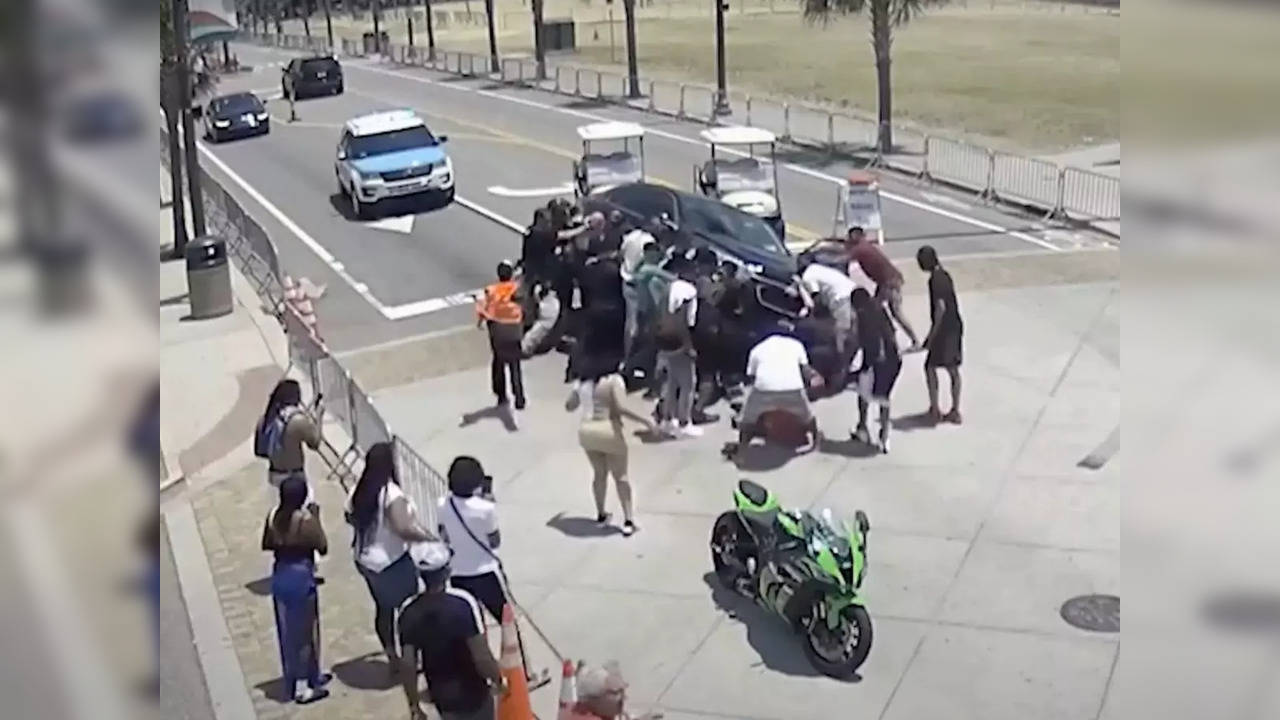 Onlookers, police rush to rescue motorcylist trapped underneath a car