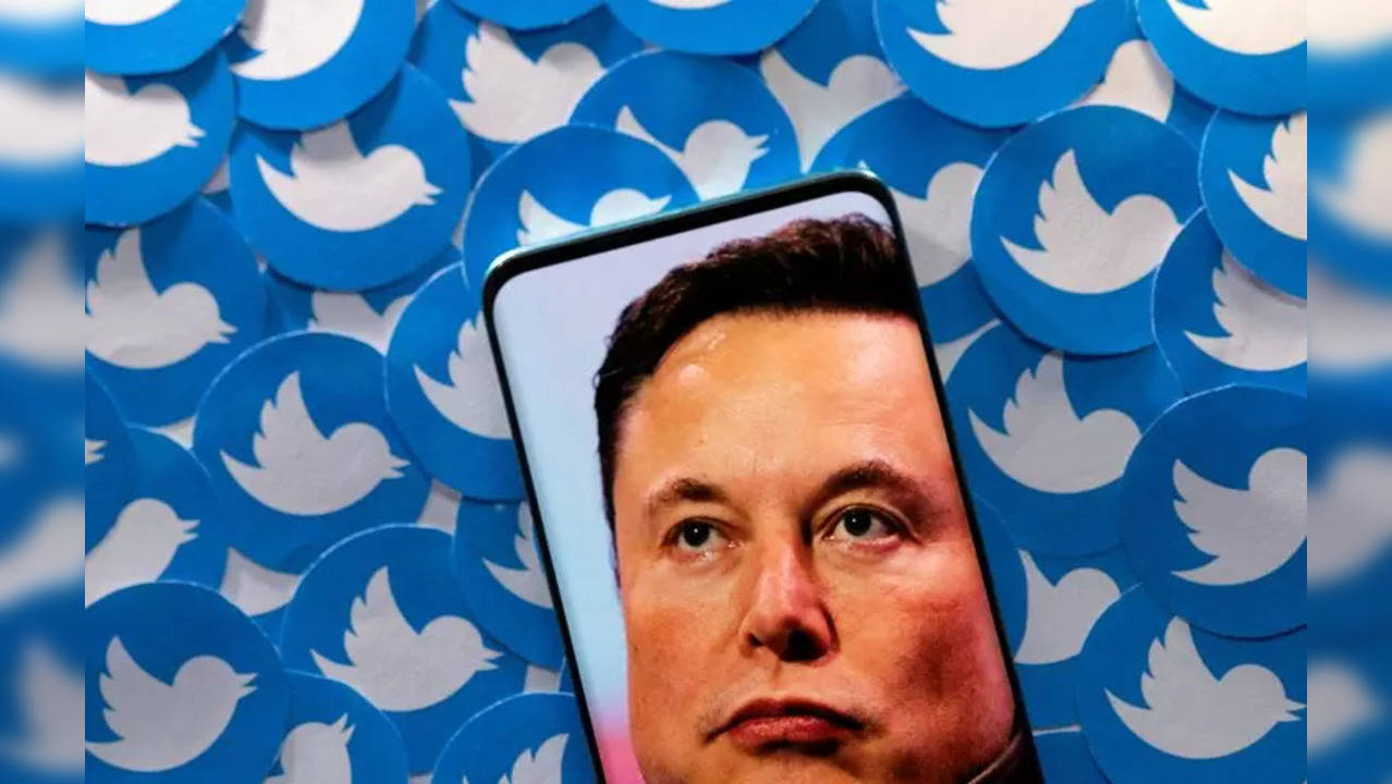 An image of Elon Musk is seen on smartphone placed on printed Twitter logos in this picture illustration.