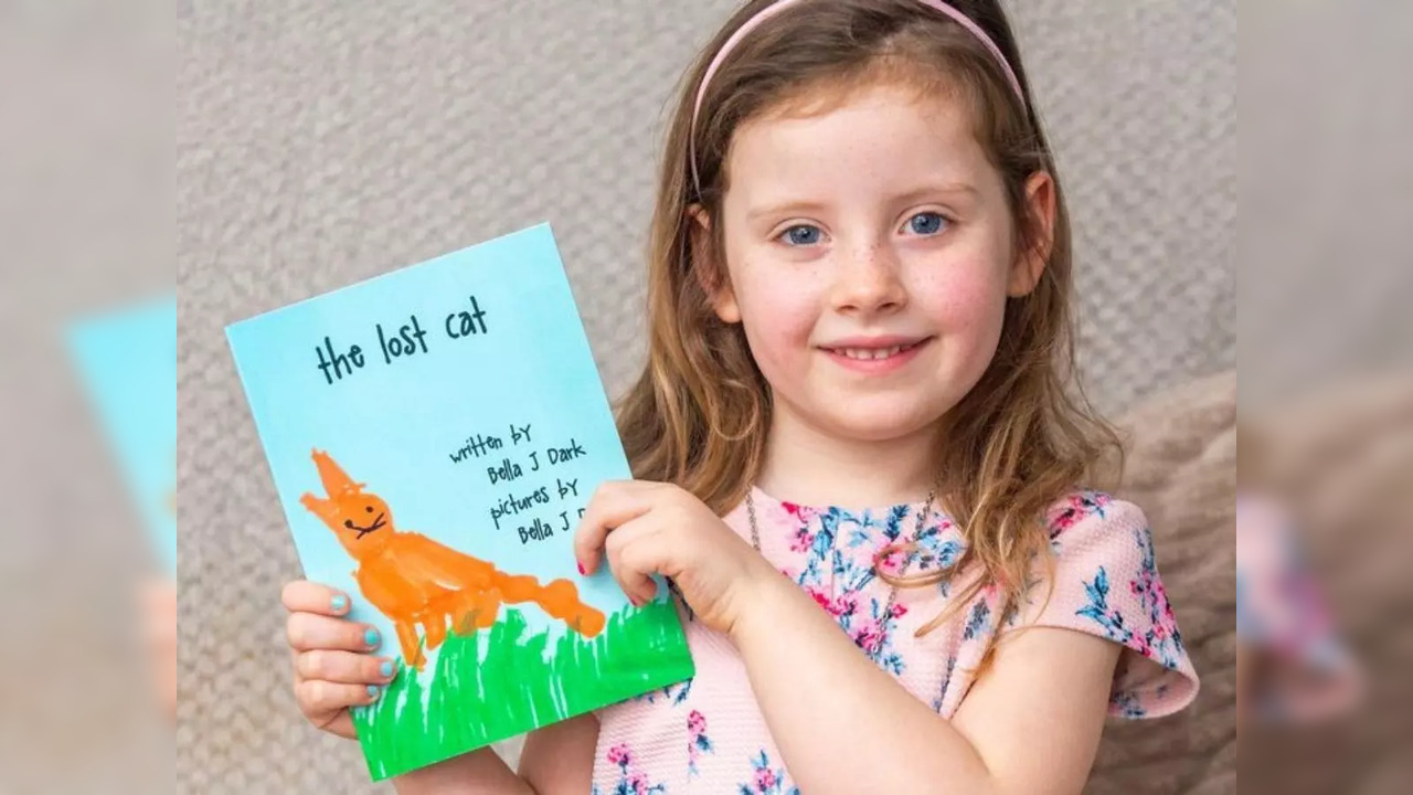 Five-year-old Bella Jay Dark pictured with her book 'The Lost Cat | Picture credit: The Sun/SWNS