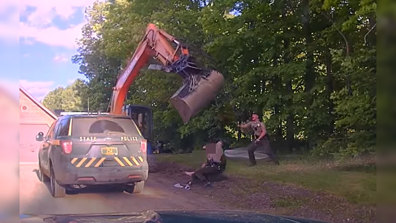 Man swings excavator at police