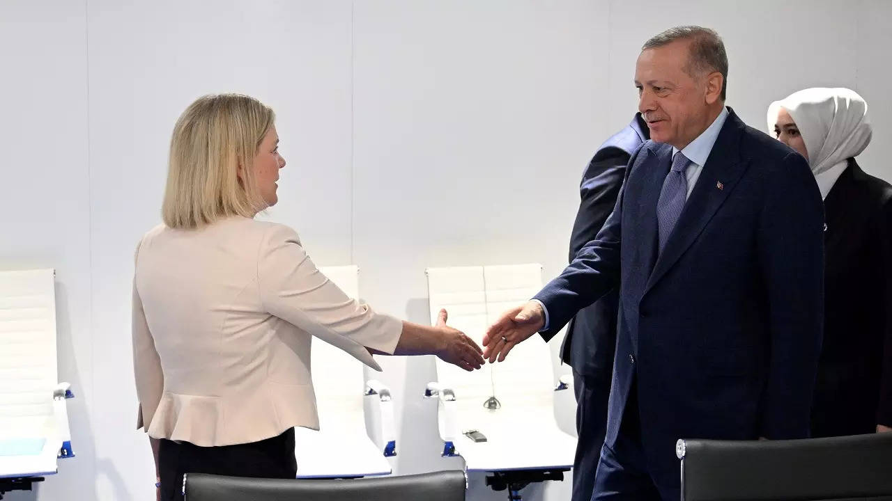 Swedish Prime Minister Magdalena Andersson, left, and Turkish President Recep Tayyip Erdogan shake hands before a meeting in Madrid