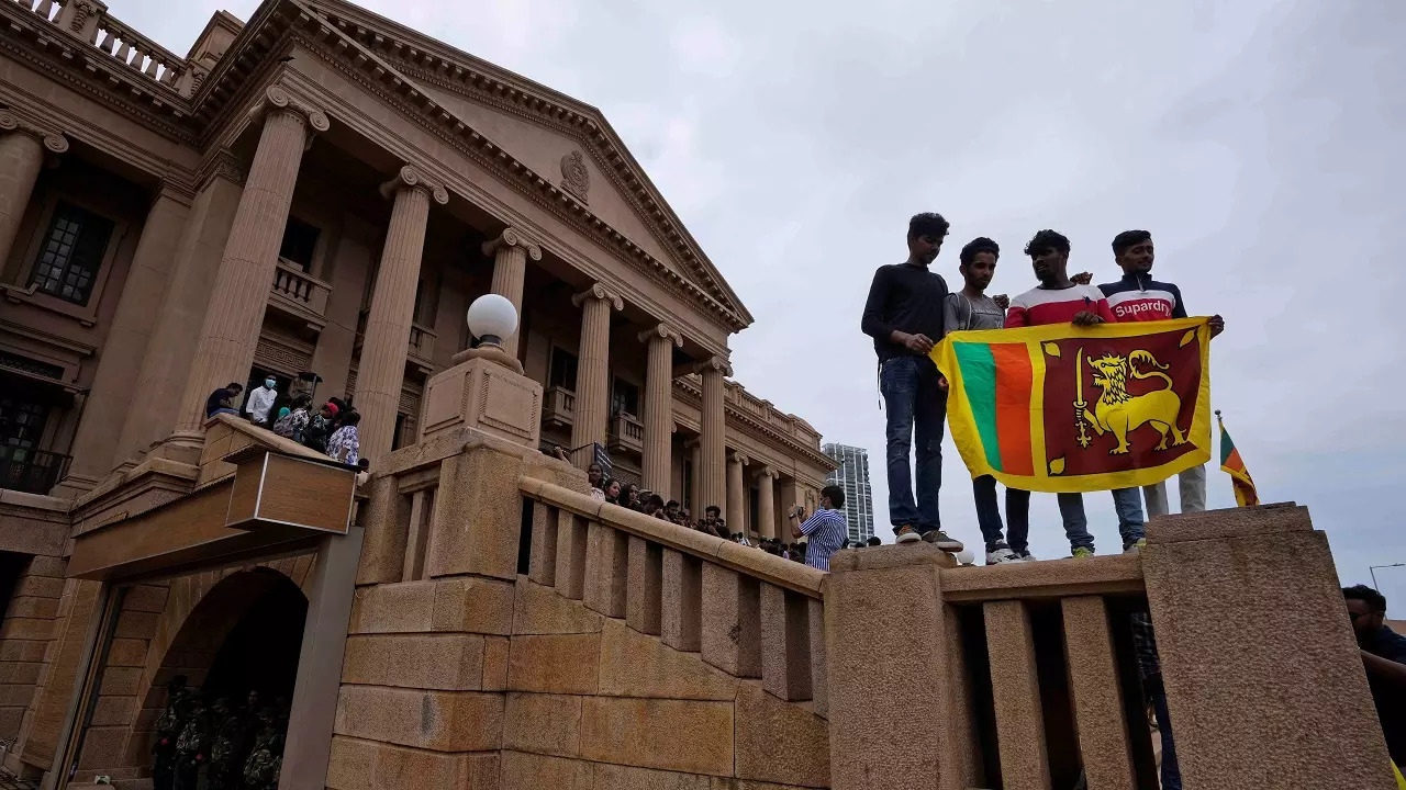 People stand holding a national flag at President Gotabaya Rajapaksa's office