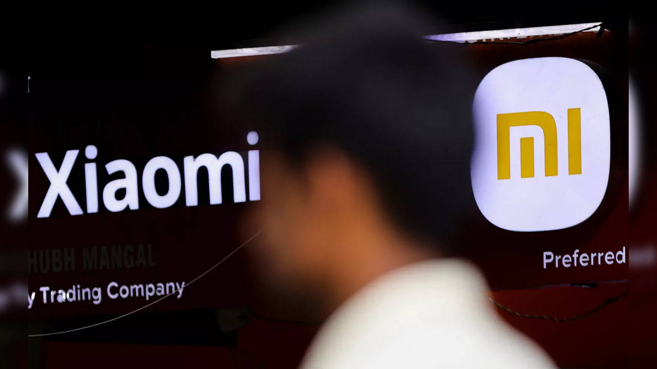 A man walks past a logo of Xiaomi, a Chinese manufacturer of consumer electronics, outside a shop in Mumbai. (Image source: REUTERS/Francis Mascarenhas)