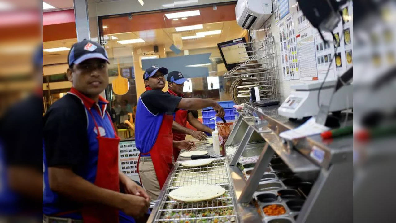 Workers prepare pizzas in the kitchen of a Domino's Pizza branch in New Delhi.