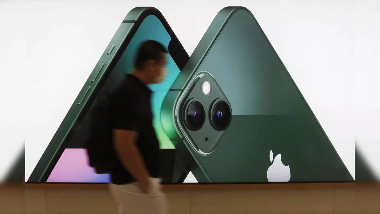 FILE PHOTO: A customer passes an Apple iPhone 13 advertisement at an Apple shop in Singapore March 18, 2022. REUTERS/Edgar Su