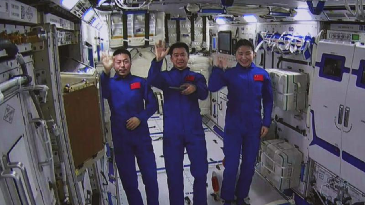 In this photo released by Xinhua News Agency, an image taken off the screen at the Beijing Aerospace Control Center shows Chinese astronauts from left, Cai Xuzhe, Chen Dong and Liu Yang wave from inside the Wentian lab module on Monday, July 25, 2022. China added the laboratory to its permanent orbiting space station Monday as it moves toward completing the structure in coming months. (Guo Zhongzheng/Xinhua via AP)