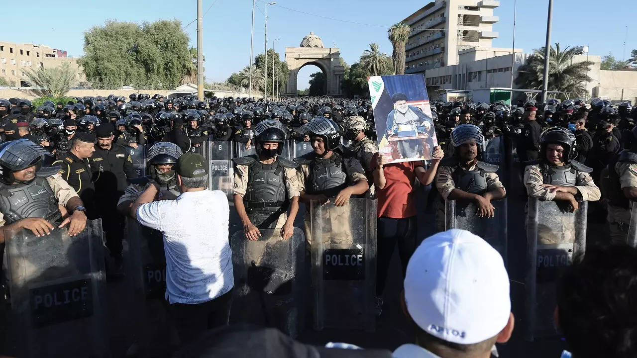 Followers of Shiite cleric Muqtada al-Sadr hold posters with his photo outside of the heavily fortified Green Zone in Baghdad