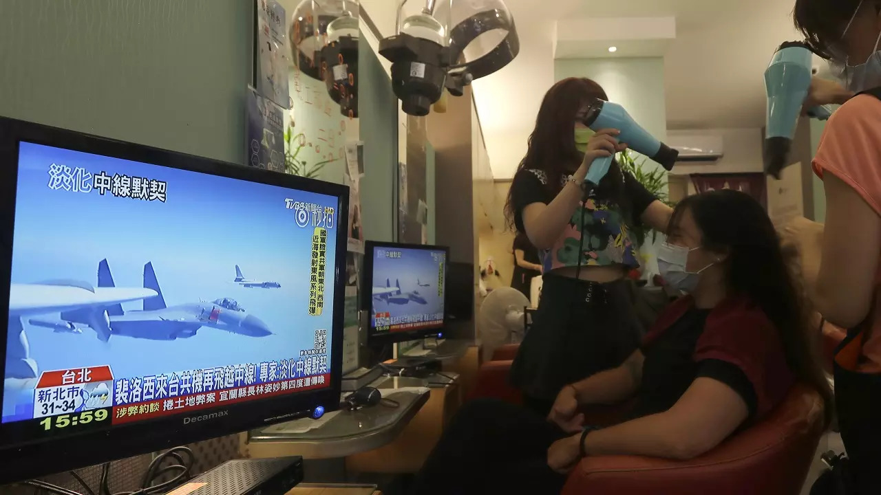 ​A customer watches a news report on the recent tensions between China and Taiwan at a beauty salon in Taipei​