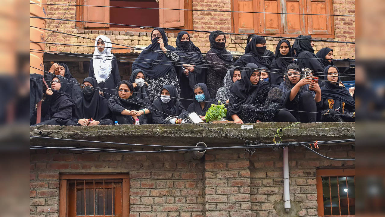 Muslim Shia women mourners watch the Muharram procession in Srinagar