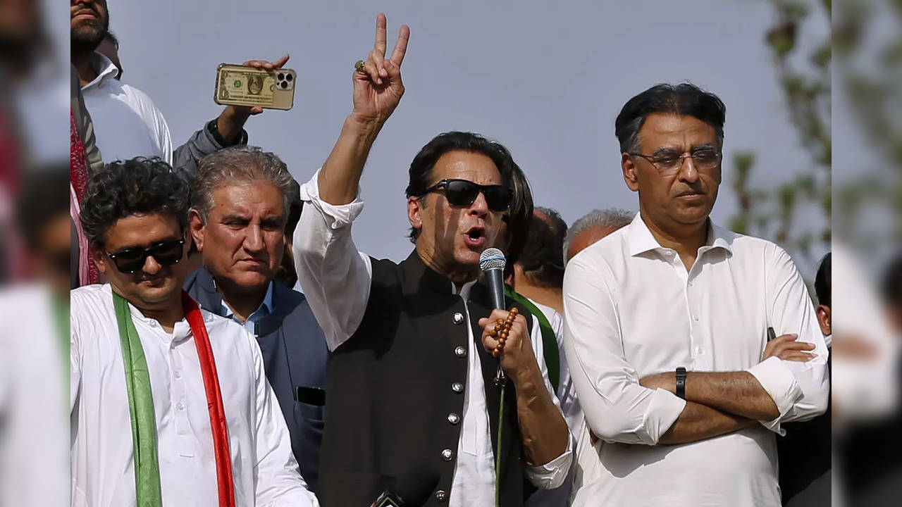 Supporters of Pakistan‚Äôs defiant former Prime Minister Imran Khan, center, add...