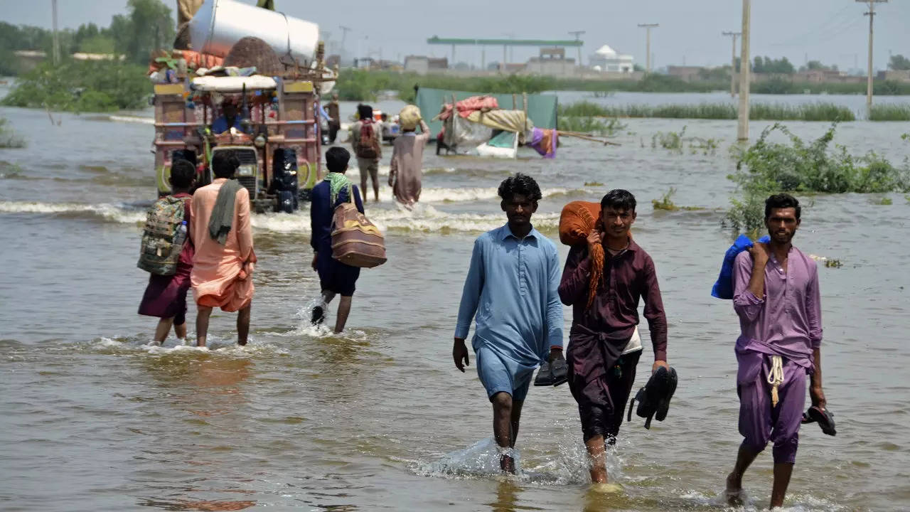 ​People wade through a flooded area of Sohbatpur - a district of Pakistan's southwestern Baluchistan province - on August 29