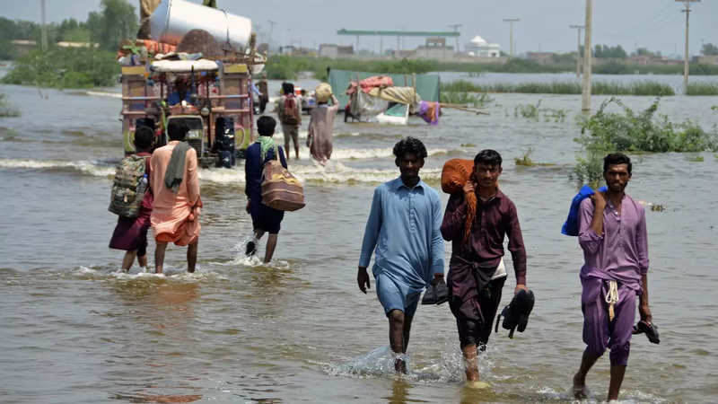 ​People wade through a flooded area of Sohbatpur - a district of Pakistan's southwestern Baluchistan province - on August 29