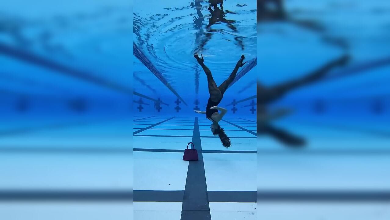 Pro swimmer walks upside down inside pool in high heels, rotates 360 ...
