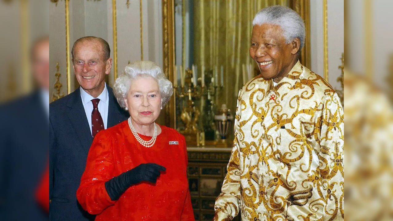 Queen Elizabeth II and the Duke of Edinburgh (left) with former South African president Nelson Mandela during a reception at Buckingham Palace, London, in October 2003. (Photo by KIRSTY WIGGLESWORTH/AFP via Getty Images)