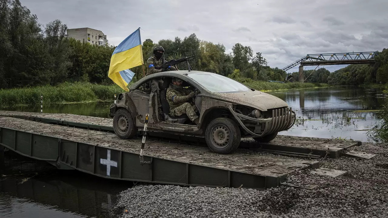 ​Ukrainian paratroopers drive on the vehicle with Ukrainian flag on the pontoon bridge across Siverskiy-Donets river in the recently retaken area of Izium