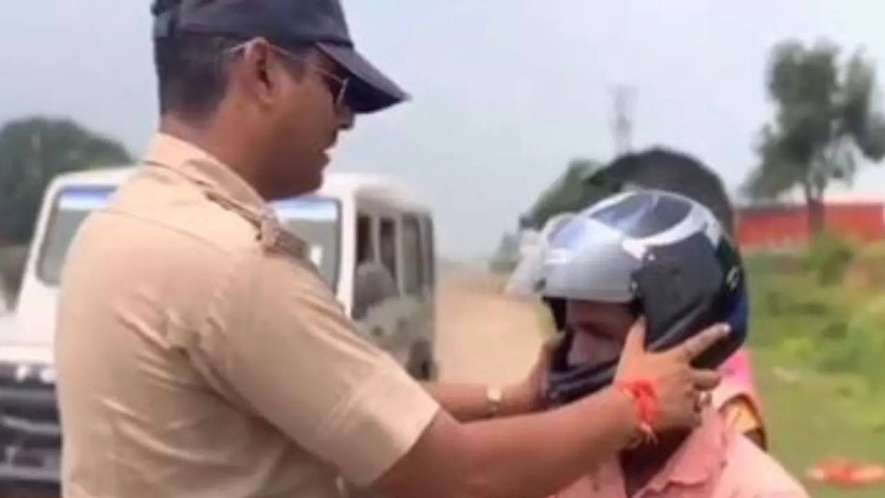 The policeman put a helmet on the man's head