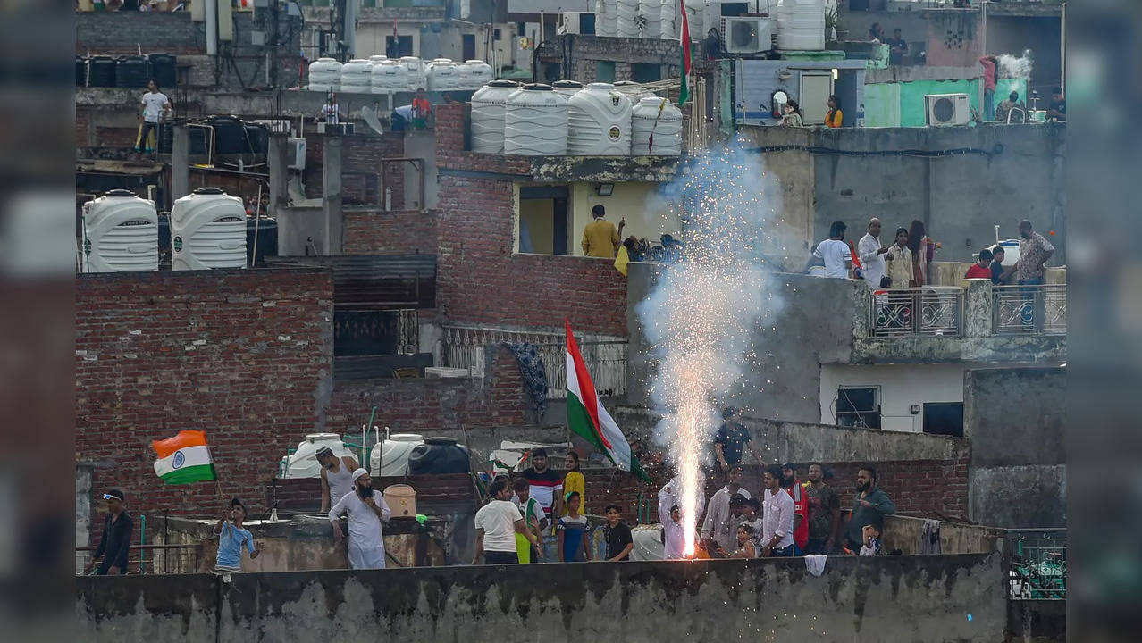 New Delhi: People burst a firecracker on the roof of their house to celebrate th...