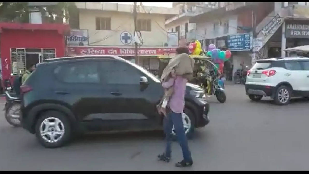 The viral video shows the man walking on road carrying the body on his shoulder to the bus stand.