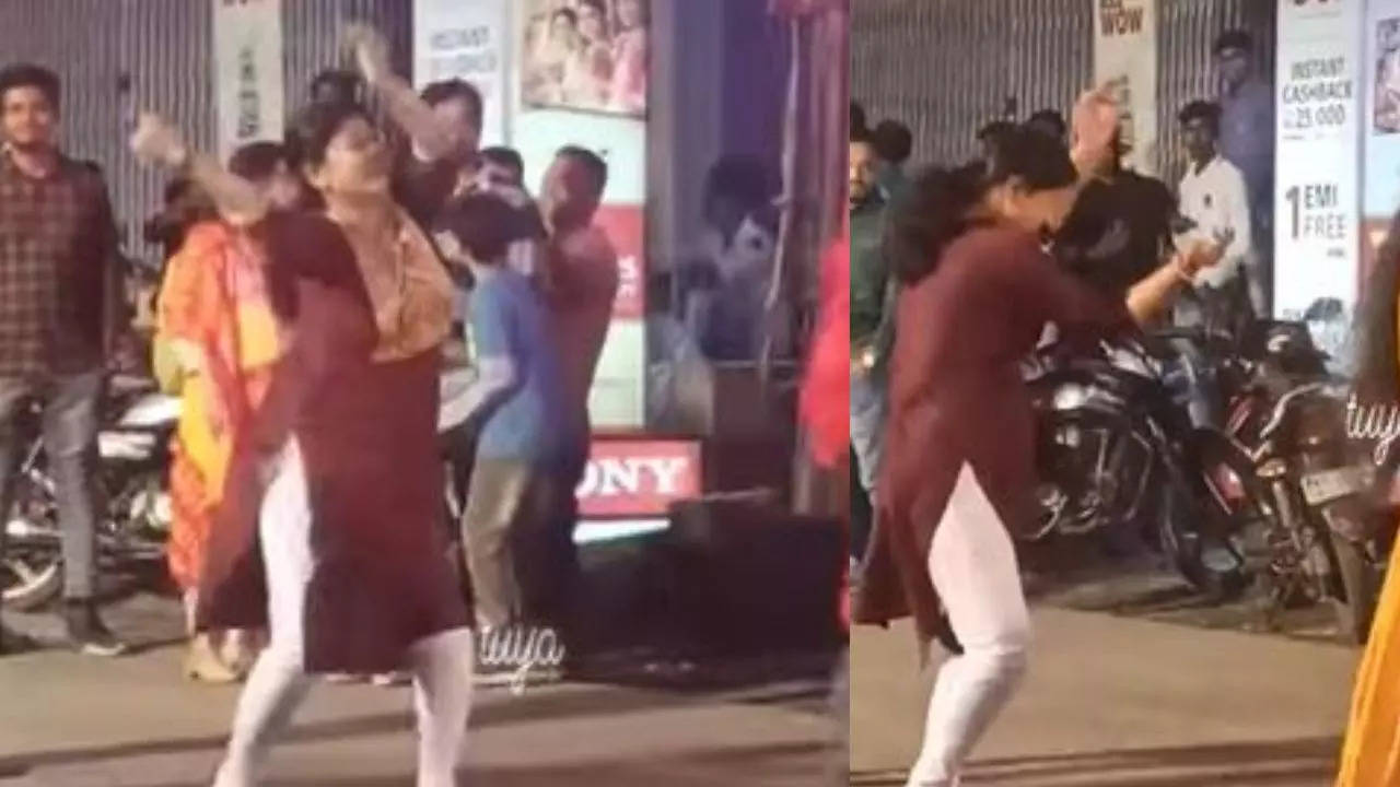 Woman dances in front of puja pandal