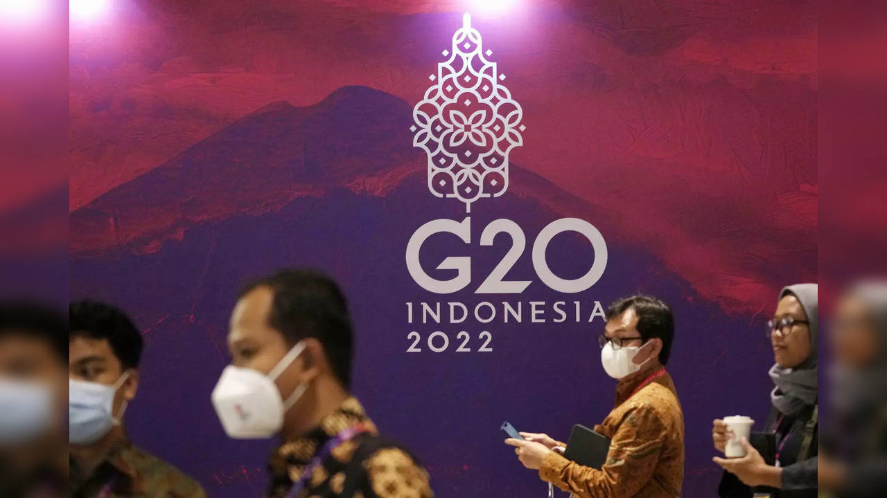 Delegates walk past a G20 sign ahead of the summit in Bali