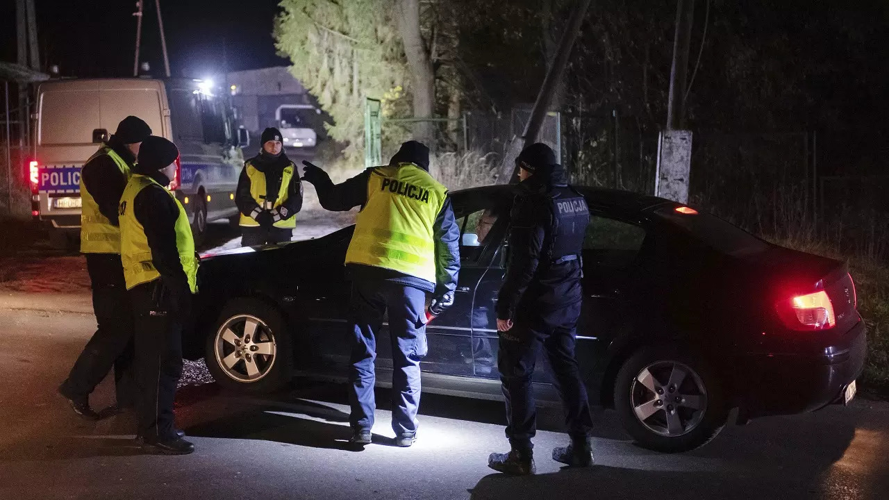 ​Police officers gather outside a grain depot in Przewodow where the Polish Foreign Ministry said that a Russian-made missile fell and killed two people.