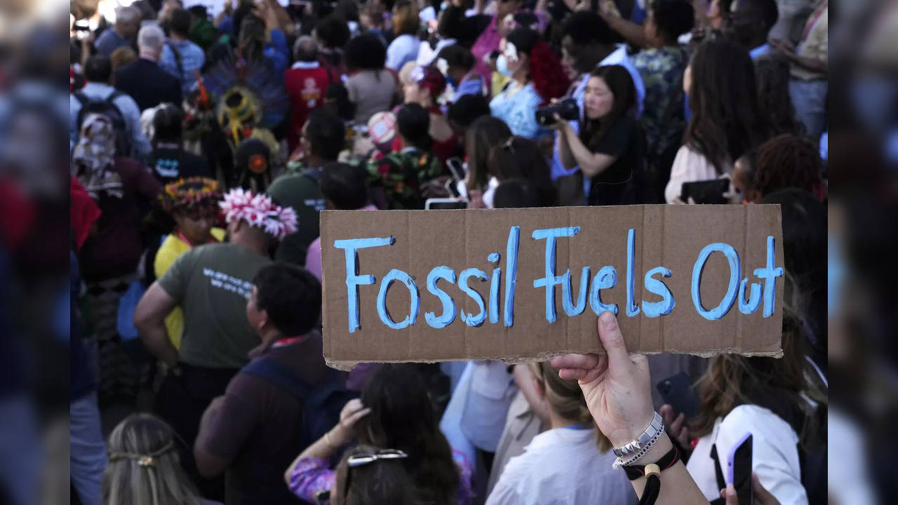 A sign reading 'fossil fuels out' is displayed during a demonstration at the COP27 UN Climate Summit