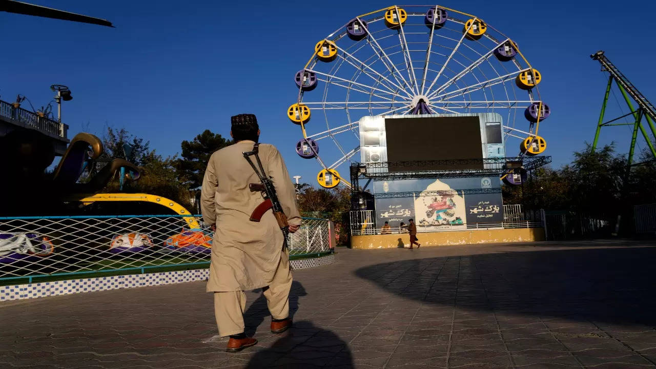 A Taliban fighter stands guard in an amusement park, in Kabul, Afghanistan