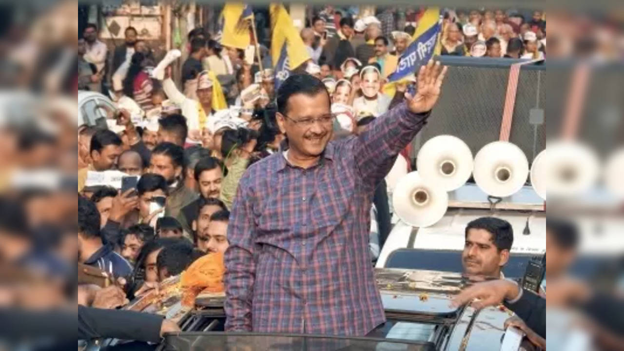 Delhi Chief Minister and AAP National Convener Arvind Kejriwal waves to party workers and supporters during a roadshow for the MCD elections