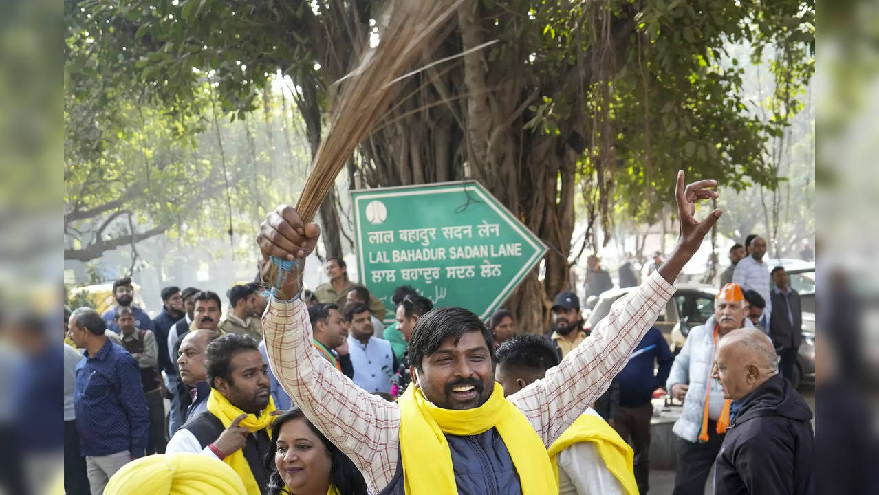 AAP supporters celebrate outside a counting centre for the MCD elections