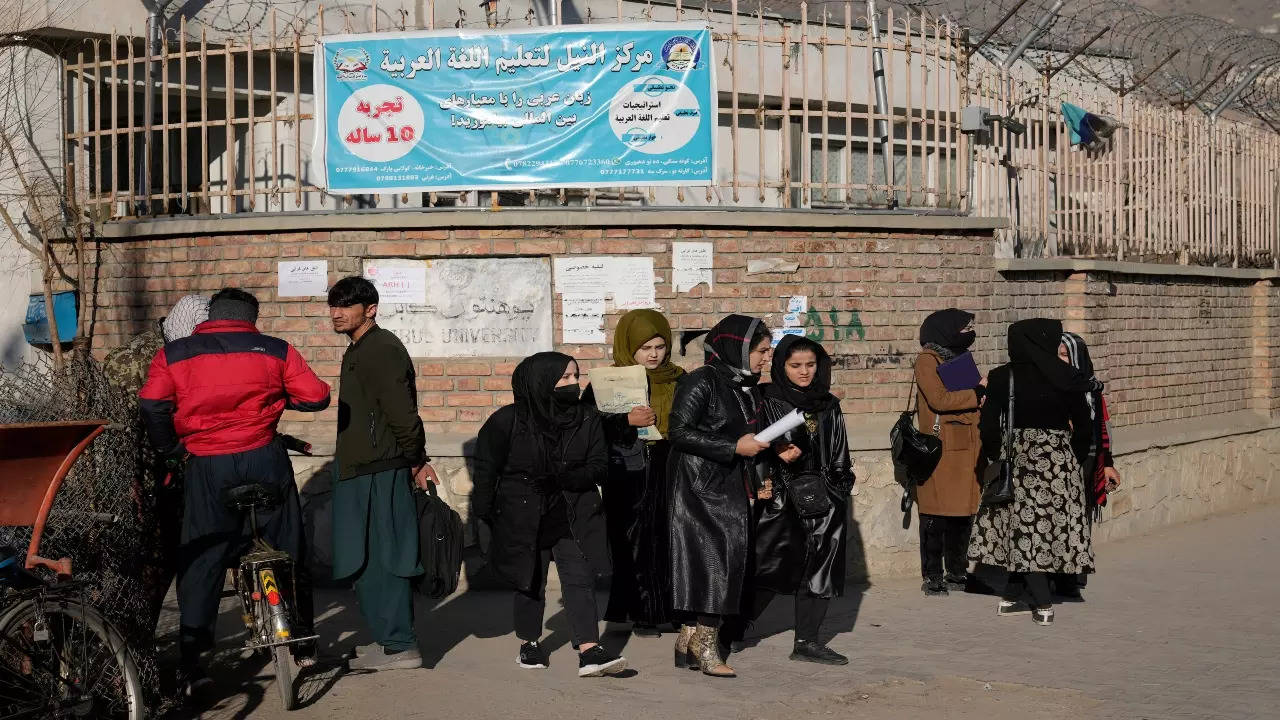 Afghan women students stand outside the Kabul University in Kabul, Afghanistan, Wednesday, Dec. 21, 2022.